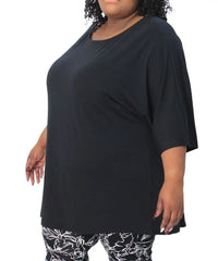 Woman in a black ladies plain batwing top and patterned pants displaying style